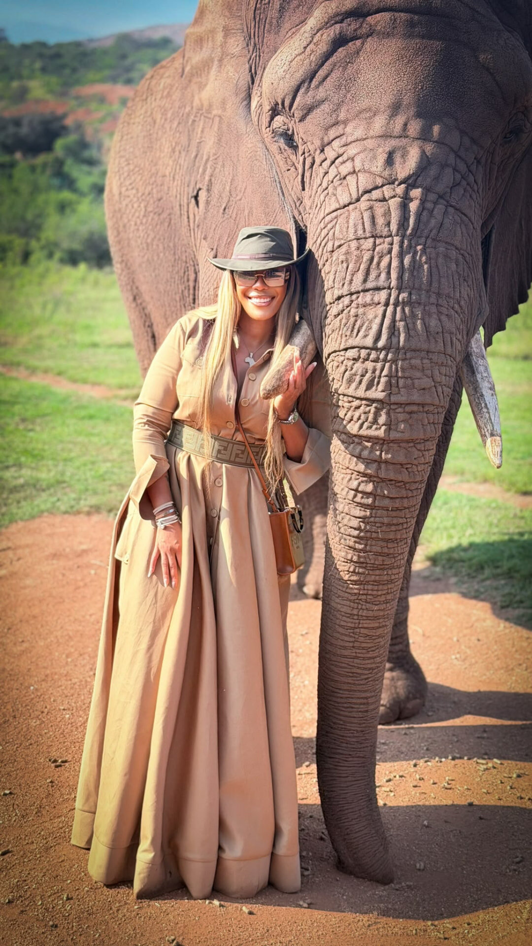 Traveler standing beside an elephant on safari