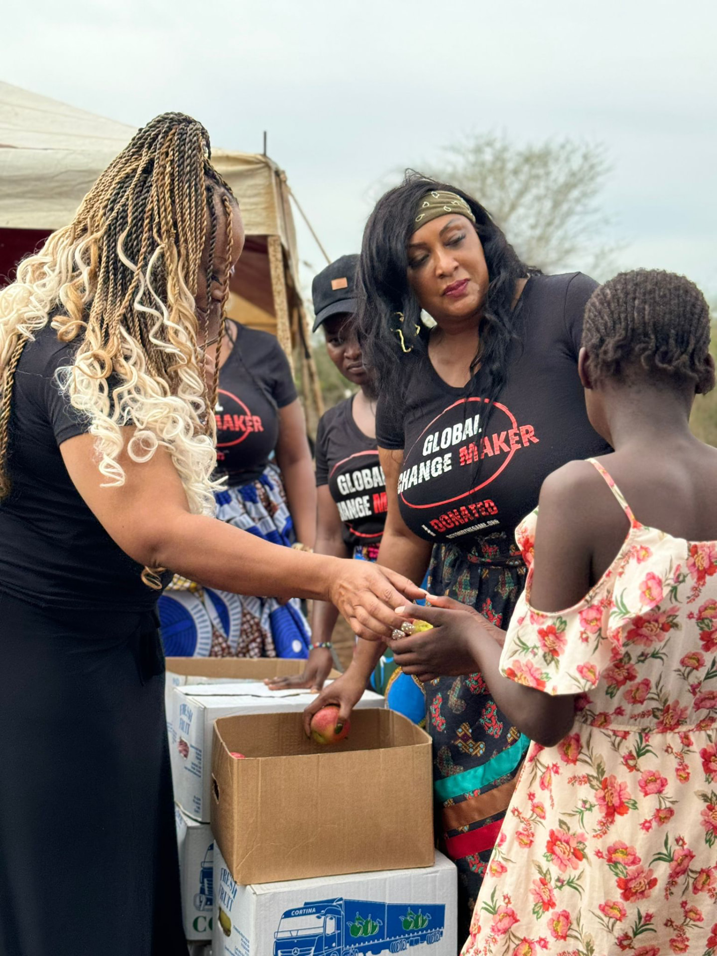 The Beyond The Game team handing fresh fruit to a child at a distribution point