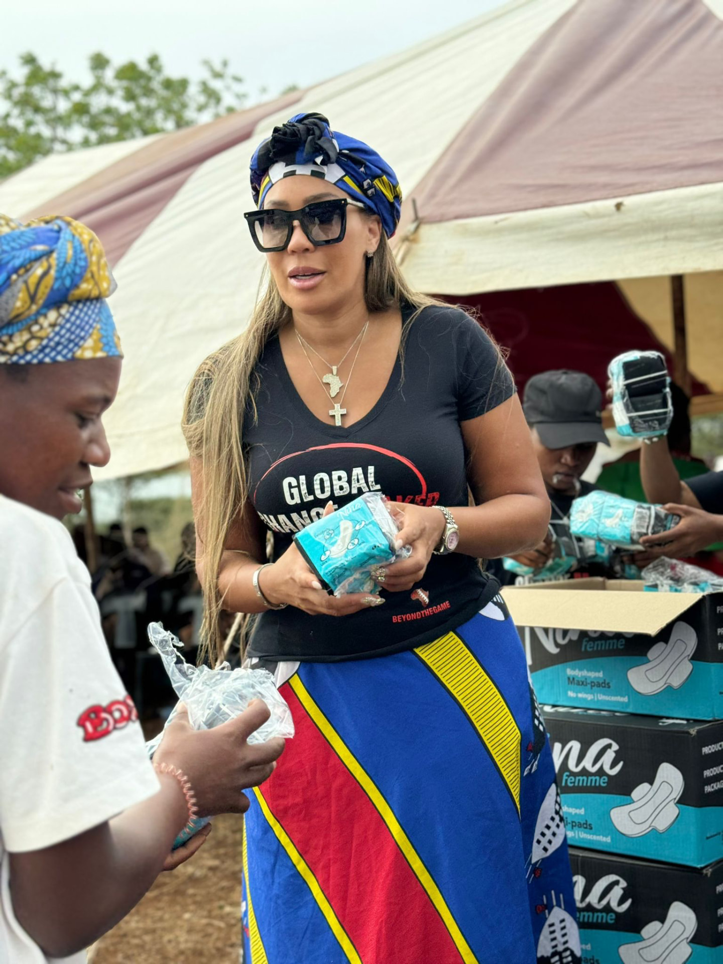 Dr Chanita Foster distributing packs of sanitary pads at a community care point