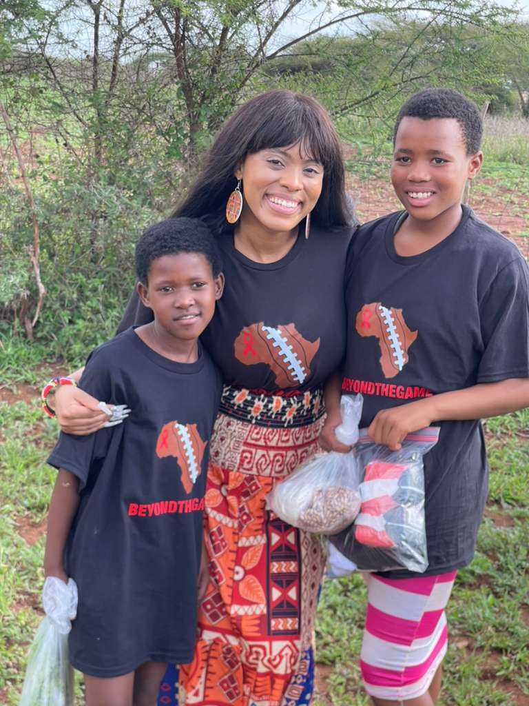 Children holding bags of beans and staples handed out at a Beyond The Game distribution